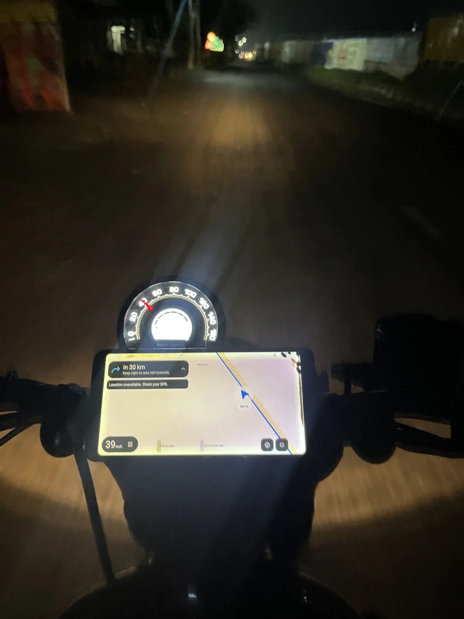 YamDrive mounted on the handlebar of the Hunter 350 at night, navigating in landscape with a card reading In 30 km, keep right to take NH16/AH45, a speed pill at 39 km/h, and the bike's own speedometer above it